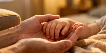 Manos de padres cuidando a un hijo enfermo, reflejando nuevos beneficios de licencia remunerada